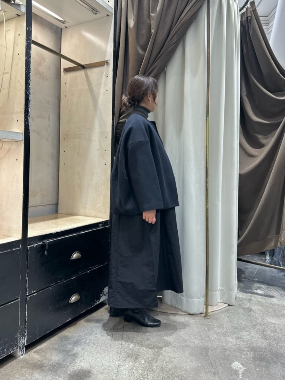 グレー系のワンピース、ブルー系のノーカラーコートを着用したレディースの冬コーディネートの2枚目の写真