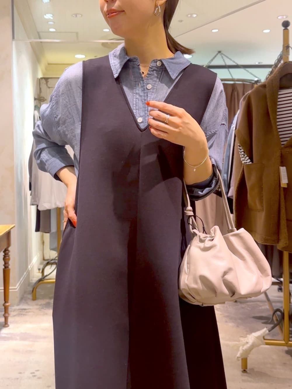 ブルー系のシャツ/ブラウス、ベージュ系のショルダーバッグ、ブラック系のジャンパースカートを着用したレディースの冬コーディネートの4枚目の写真