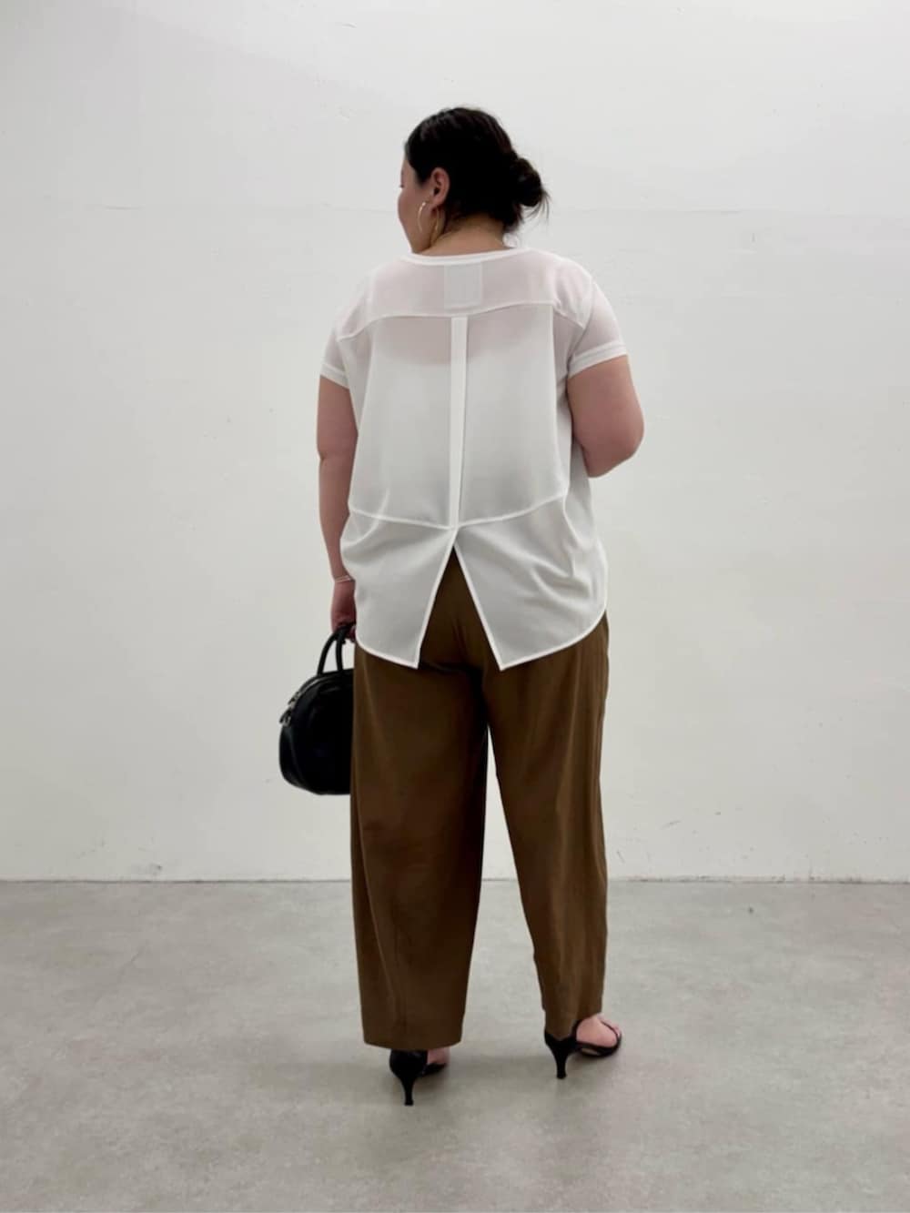 ブラック系のボストンバッグ、ホワイト系のシャツ/ブラウス、ブラウン系のその他パンツを着用したレディースの春コーディネートの6枚目の写真