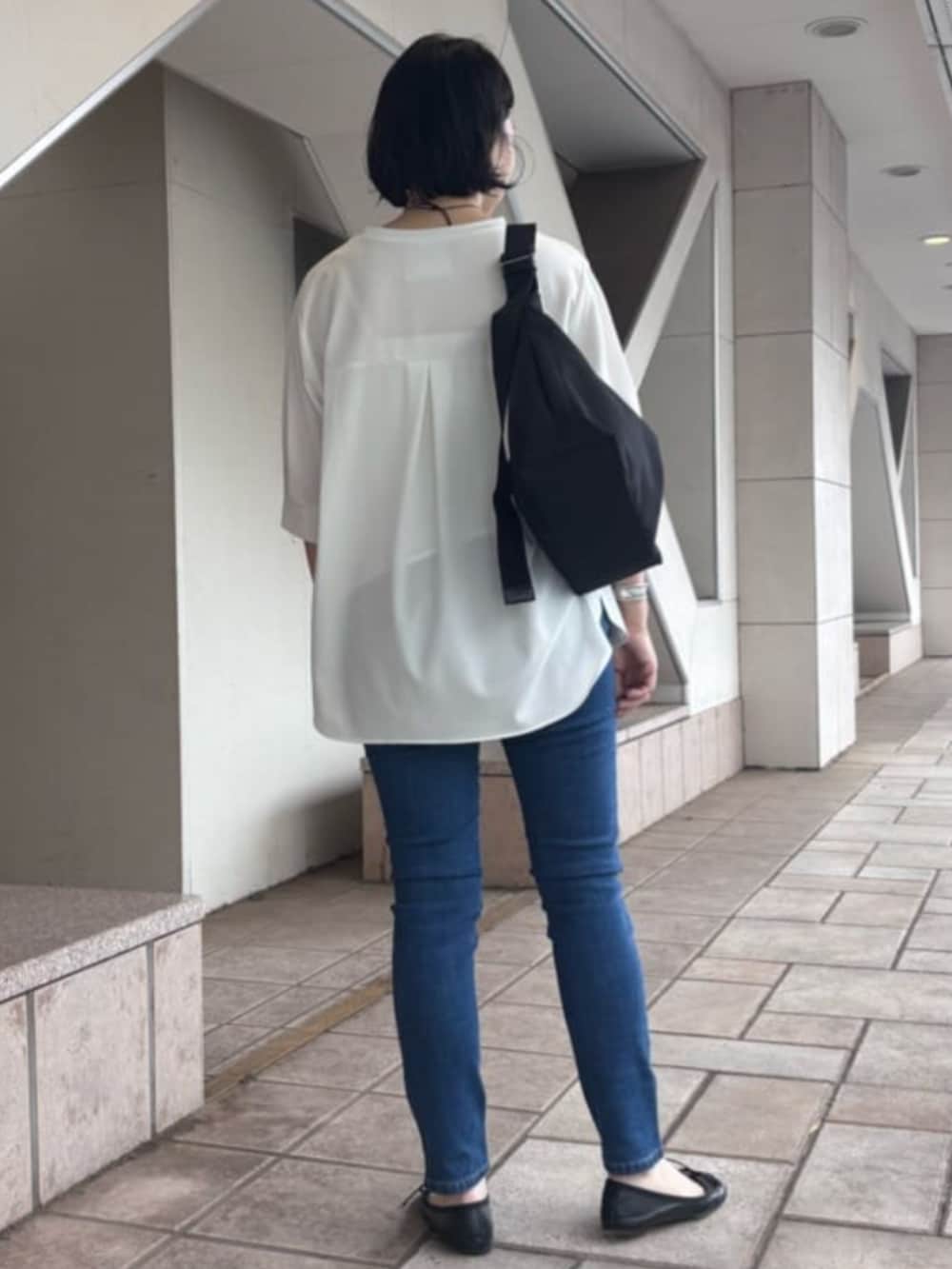 ブルー系のデニムパンツ、ホワイト系のTシャツ/カットソー、シルバー系のリングを着用したレディースの夏コーディネートの2枚目の写真
