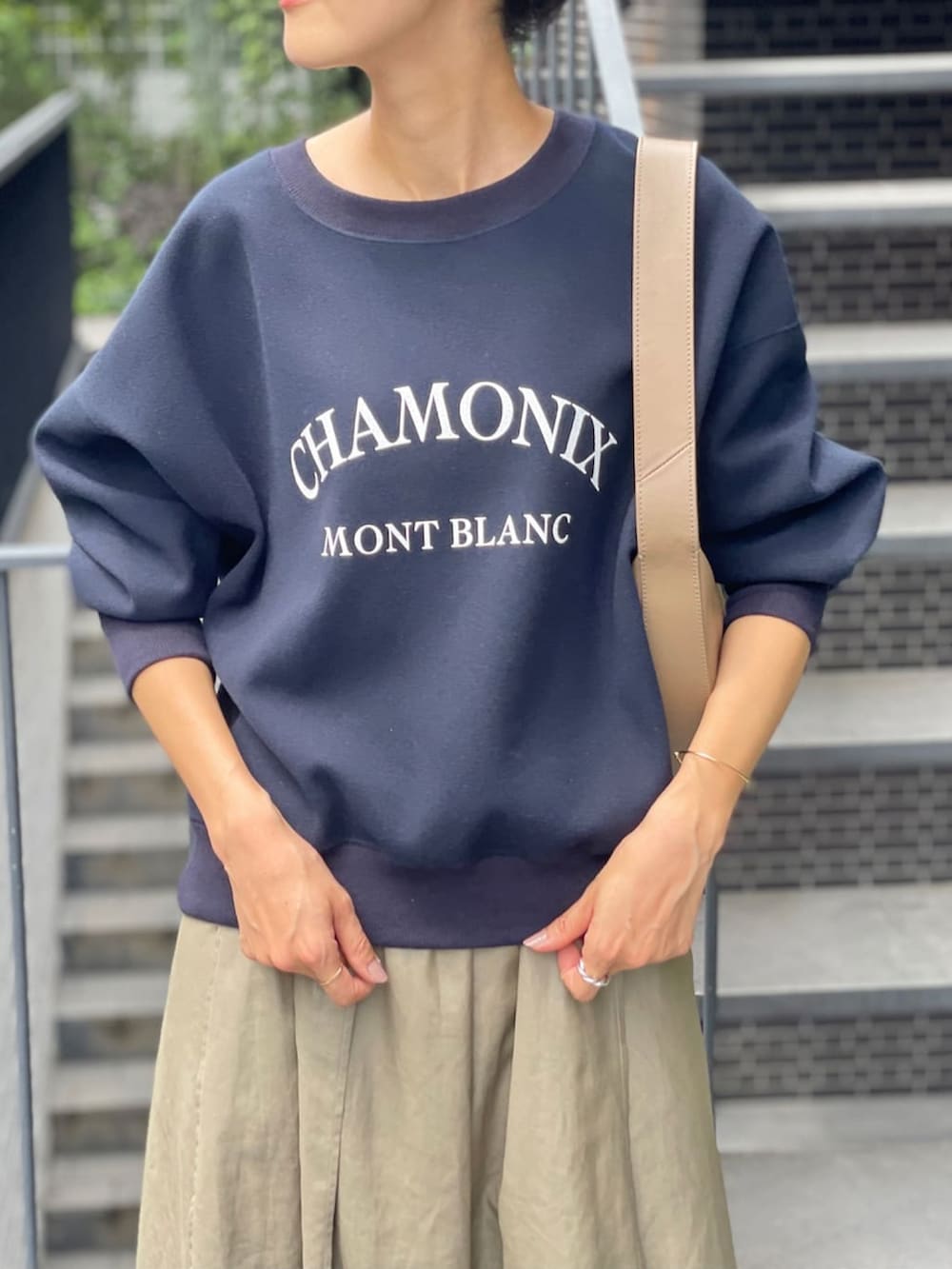 ブルー系のTシャツ/カットソー、グリーン系のスカートを着用したレディースの秋コーディネートの2枚目の写真