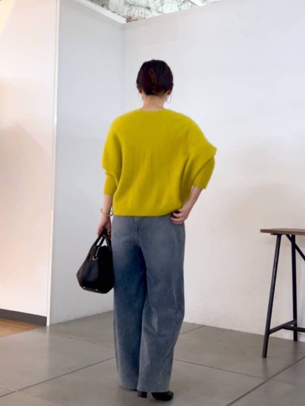 ブラック系のトートバッグ、イエロー系のニット/セーター、ブルー系のその他パンツを着用したレディースの秋コーディネートの8枚目の写真