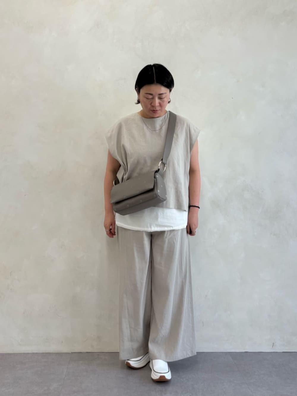 グレー系のショルダーバッグ、ホワイト系のシャツ/ブラウス、グレー系のシャツ/ブラウスを着用したレディースの春コーディネートの2枚目の写真