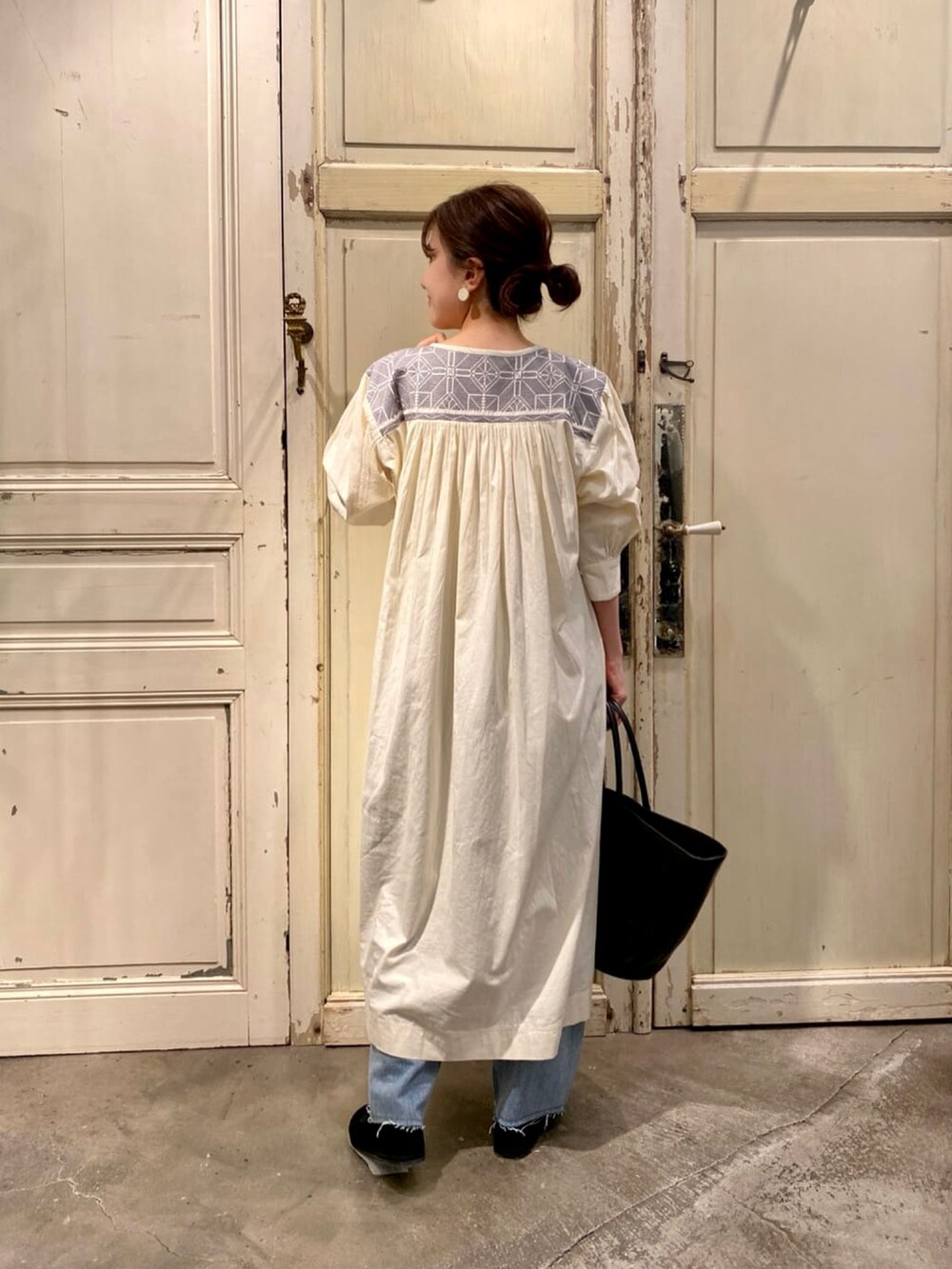 ホワイト系のワンピース、ブルー系のデニムパンツを着用したレディースの夏コーディネートの3枚目の写真