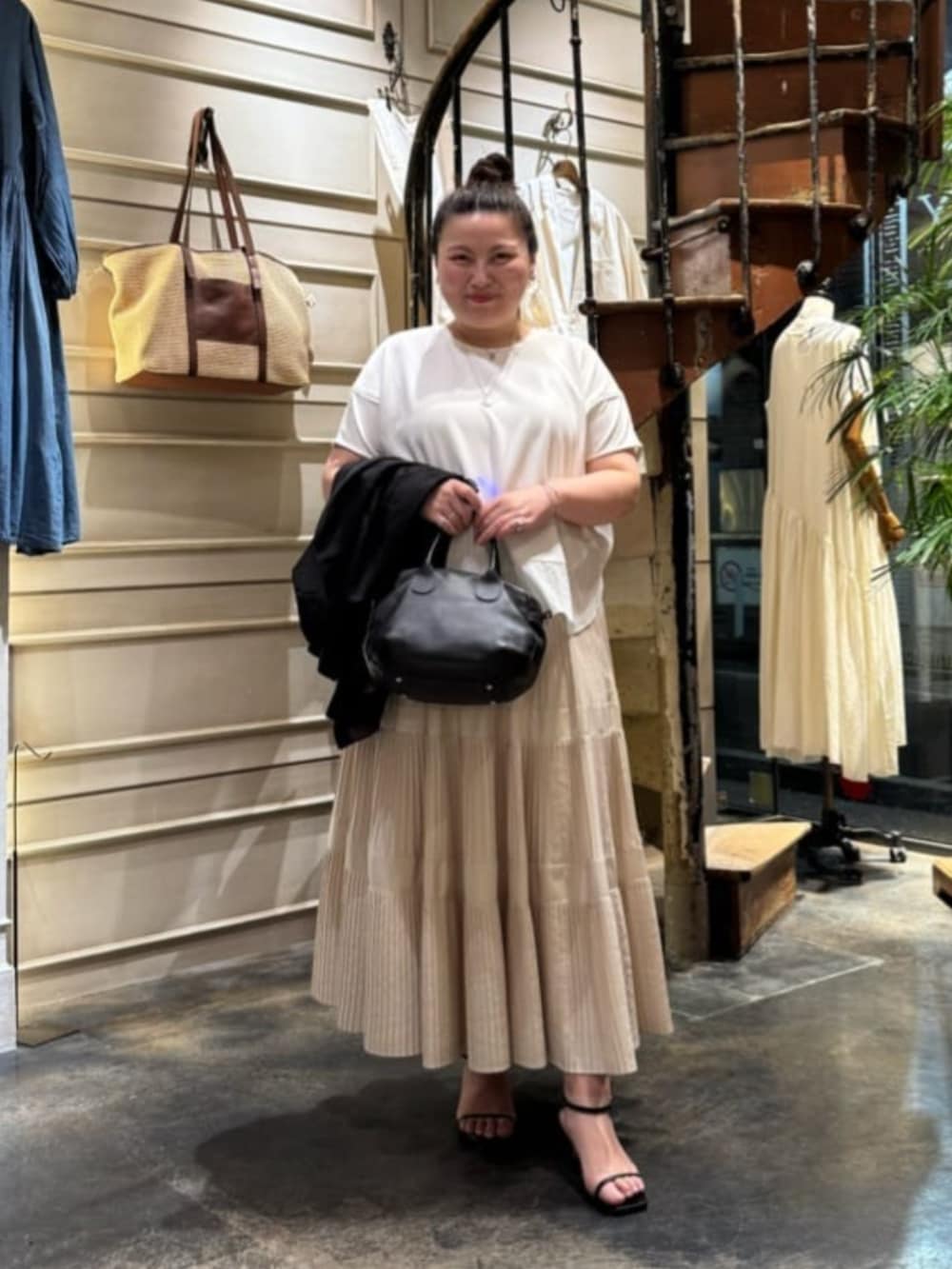 ホワイト系のスカート、ブラック系のテーラードジャケットを着用したレディースの春コーディネートの6枚目の写真