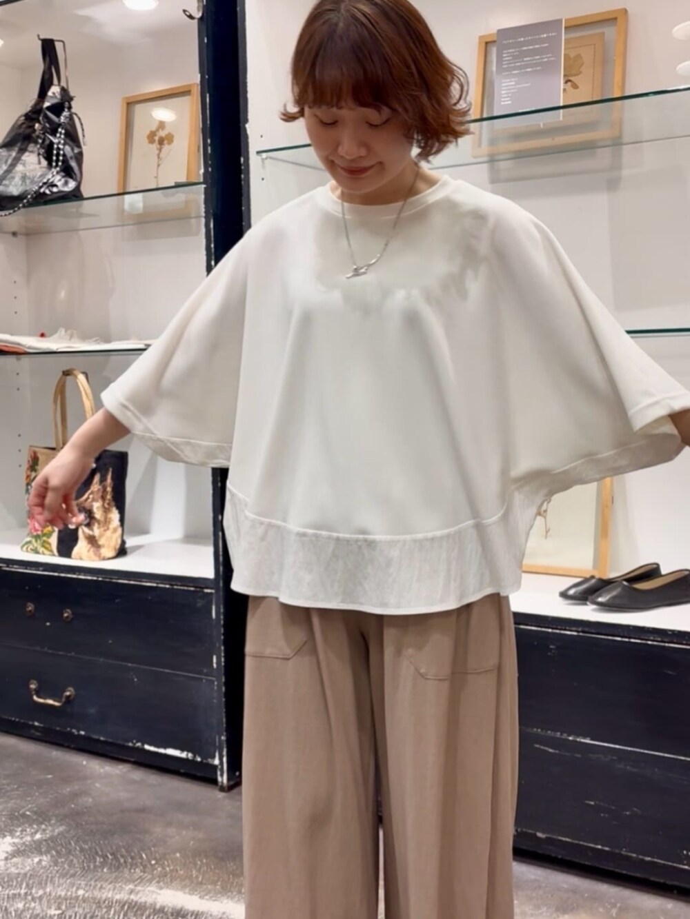 ベージュ系のその他パンツ、ブラック系のトートバッグ、ホワイト系のTシャツ/カットソーを着用したレディースの春コーディネートの5枚目の写真