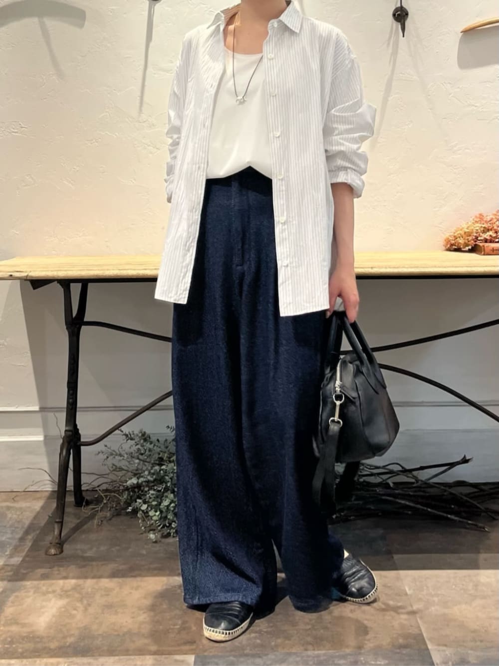 ブラック系のボストンバッグ、ブルー系のその他パンツ、ホワイト系のシャツ/ブラウスを着用したレディースの冬コーディネートの5枚目の写真