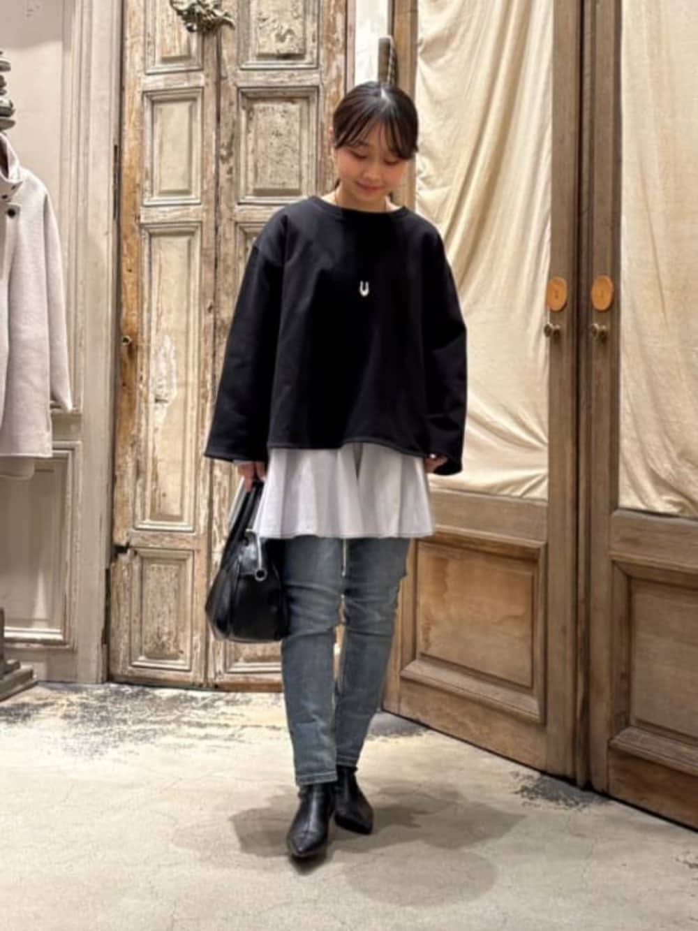 ブルー系のデニムパンツ、ブラック系のTシャツ/カットソーを着用したレディースの冬コーディネートの5枚目の写真