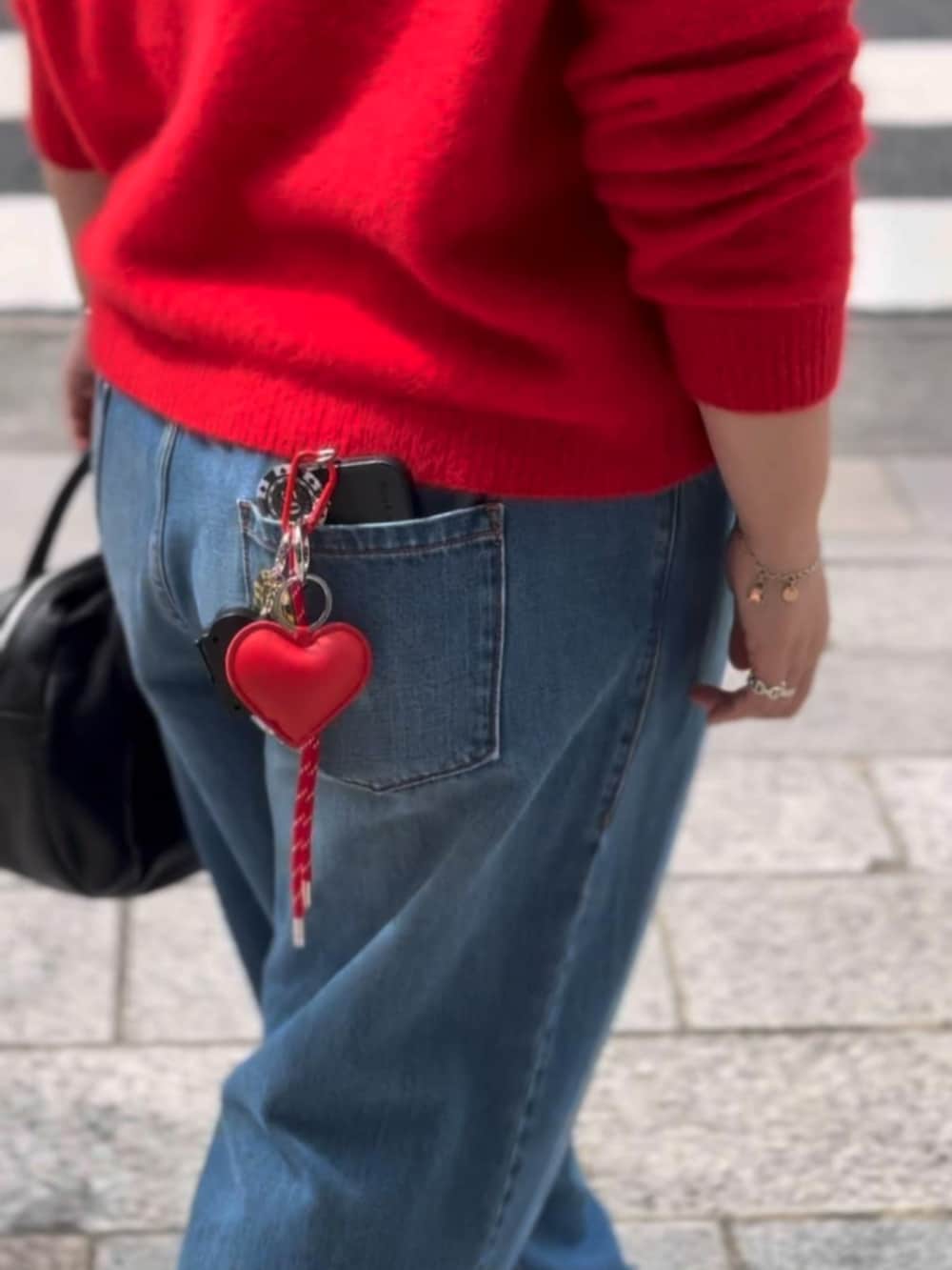 レッド系のニット/セーター、レッド系のチャームを着用したレディースの秋コーディネートの5枚目の写真