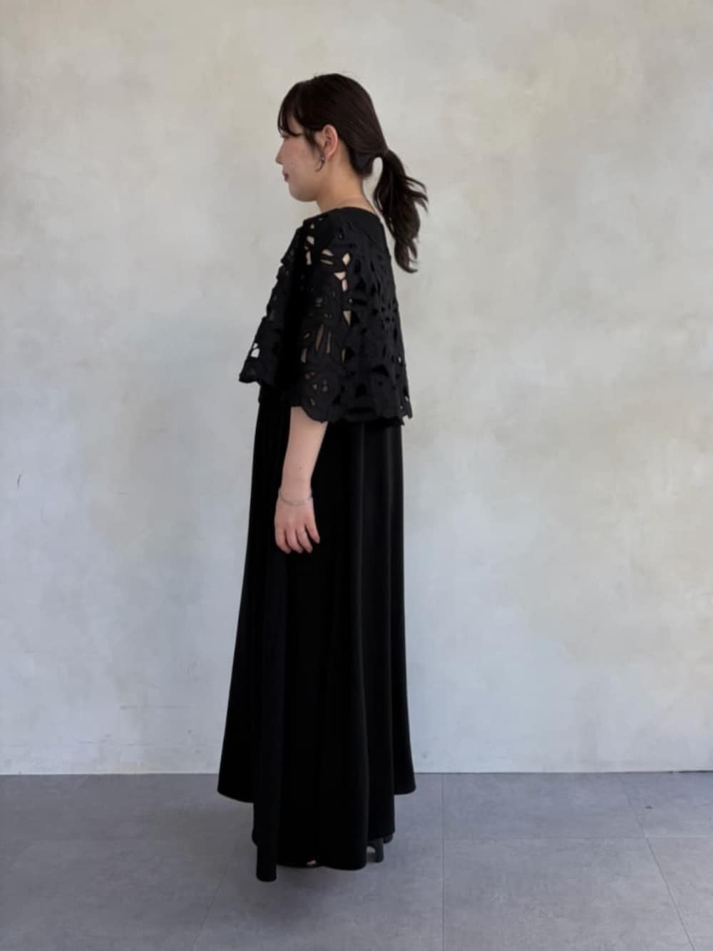 グレー系のハンドバッグ、ブラック系のワンピース、ブラック系のシャツ/ブラウスを着用したレディースの春コーディネートの3枚目の写真