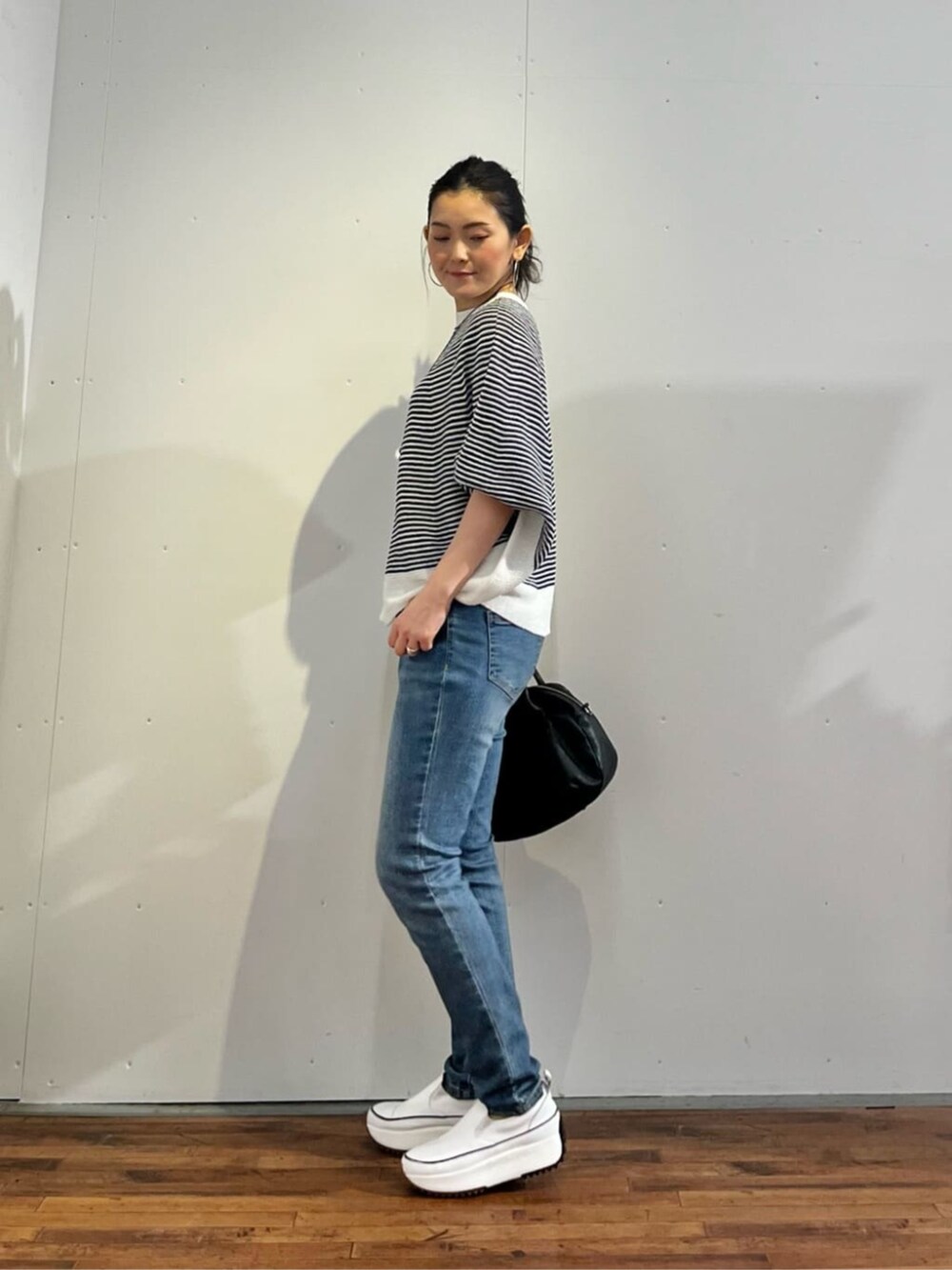 ブルー系のデニムパンツ、ブルー系のニット/セーターを着用したレディースの春コーディネートの4枚目の写真