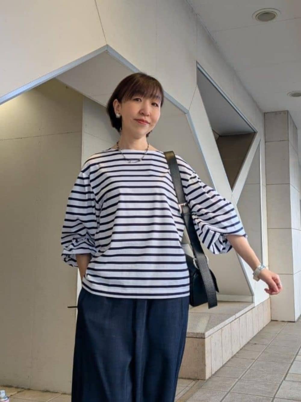 ブルー系のその他パンツ、ホワイト系のTシャツ/カットソー、ホワイト系のスニーカーを着用したレディースの春コーディネートの4枚目の写真