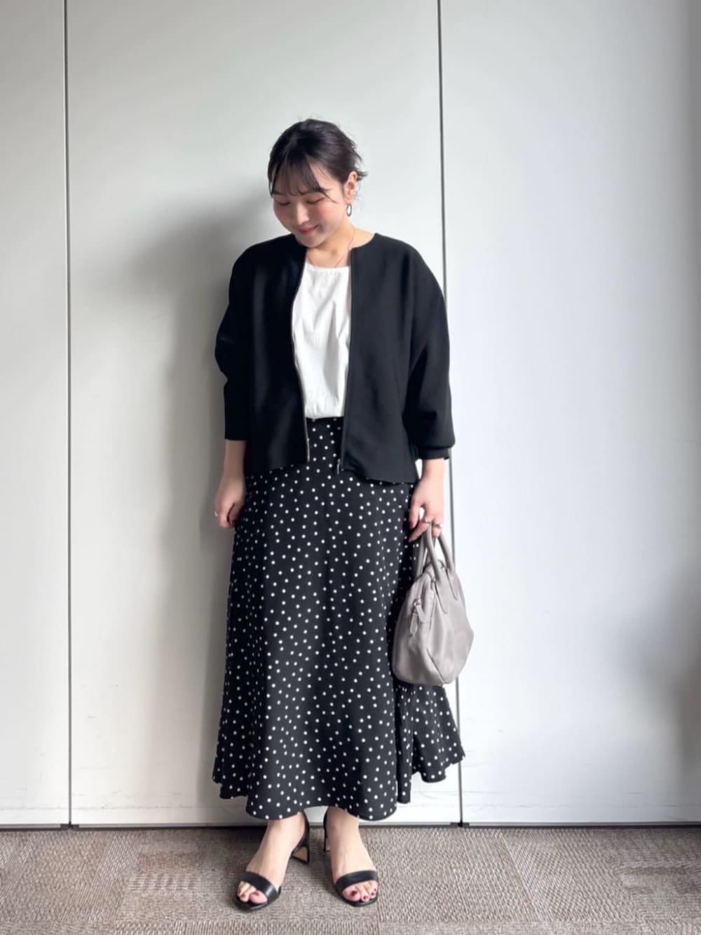 ブラック系のカーディガン/ボレロ、グレー系のボストンバッグ、ブラック系のスカートを着用したレディースの冬コーディネートの4枚目の写真