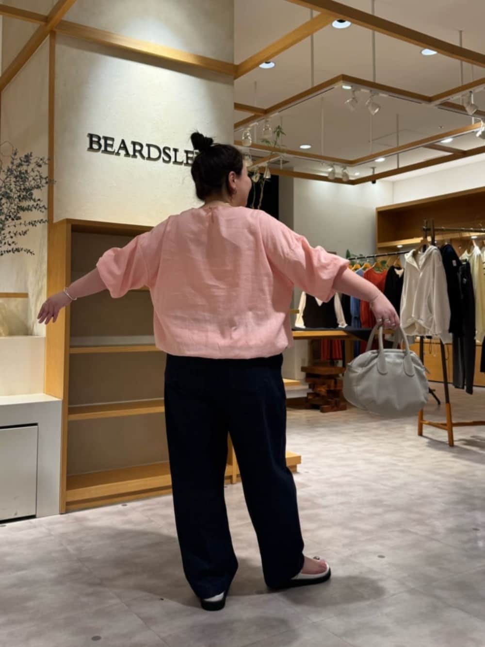 グレー系のボストンバッグ、ピンク系のシャツ/ブラウス、ホワイト系のサンダルを着用したレディースの冬コーディネートの5枚目の写真