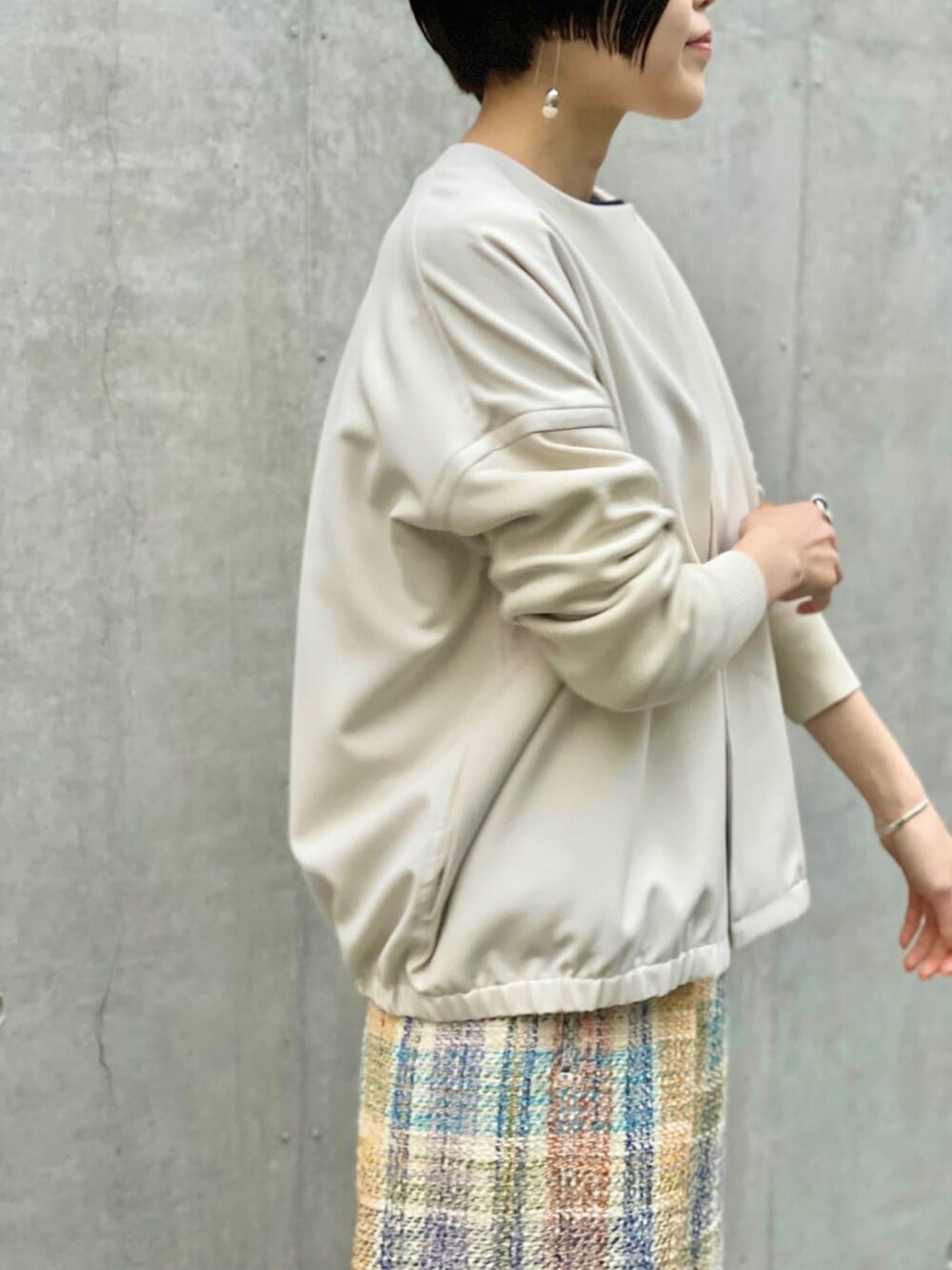 ホワイト系のノーカラージャケット、ブルー系のその他パンツを着用したレディースの春コーディネートの3枚目の写真