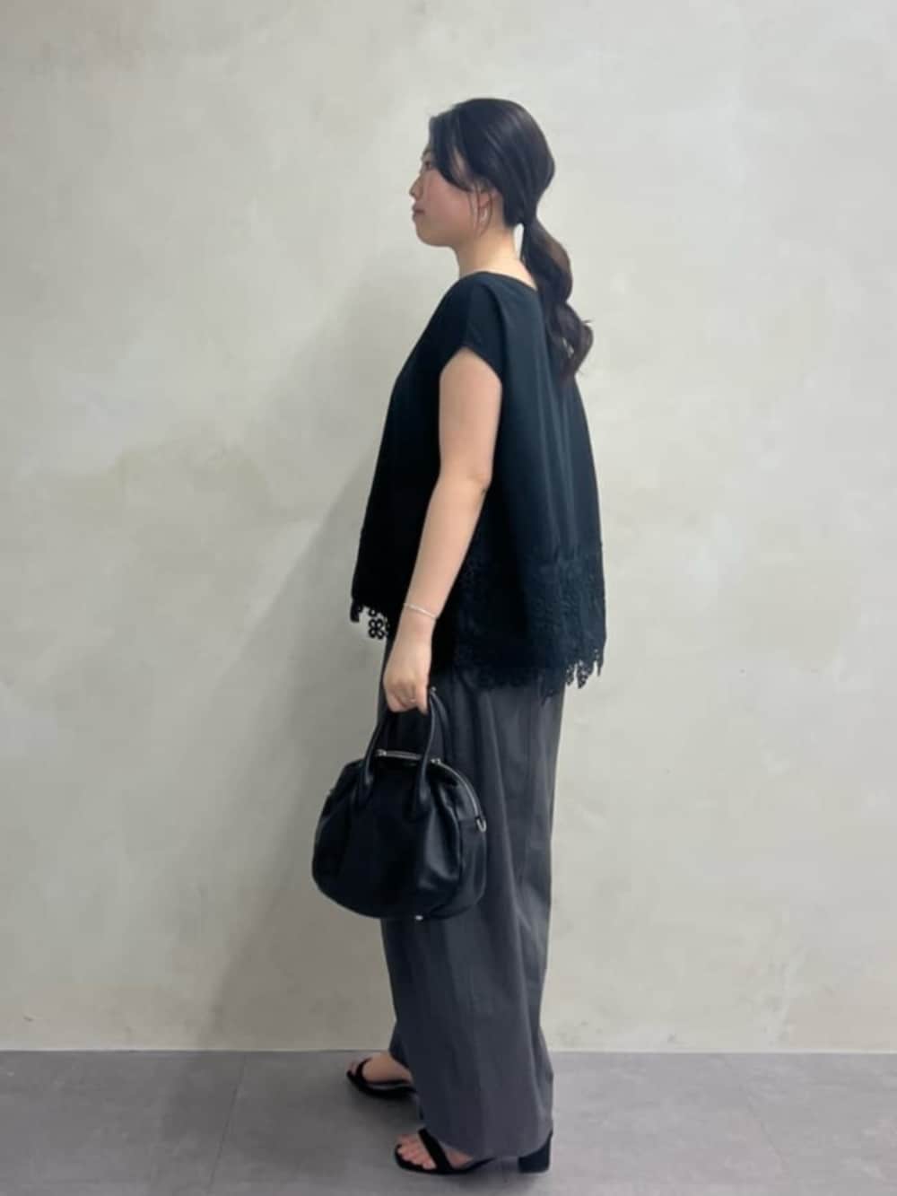 ブラック系のボストンバッグ、グレー系のその他パンツ、ブラック系のTシャツ/カットソーを着用したレディースの冬コーディネートの3枚目の写真