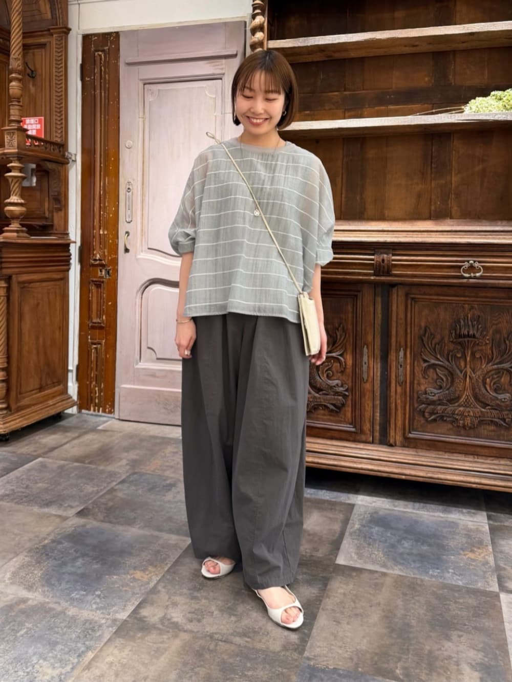 ホワイト系のショルダーバッグ、グレー系のシャツ/ブラウス、グレー系のその他パンツを着用したレディースの春コーディネートの2枚目の写真