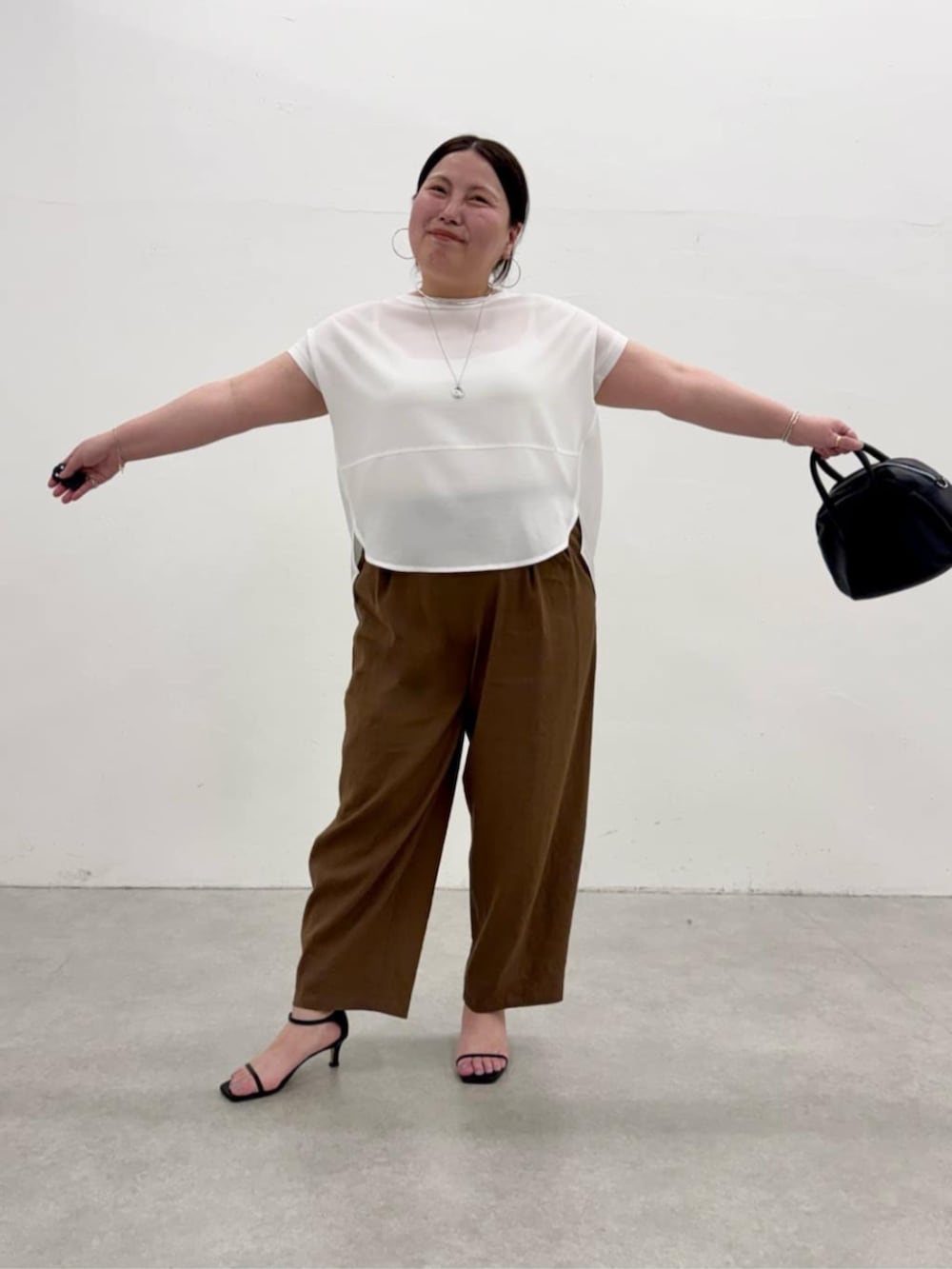 ブラック系のボストンバッグ、ホワイト系のシャツ/ブラウス、ブラウン系のその他パンツを着用したレディースの春コーディネートの7枚目の写真