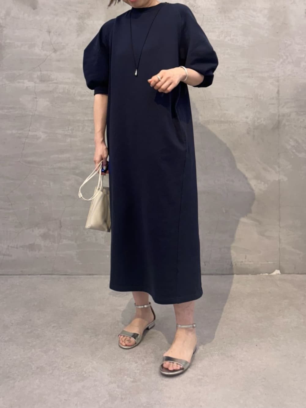 ホワイト系のショルダーバッグ、ブルー系のワンピースを着用したレディースの冬コーディネートの7枚目の写真