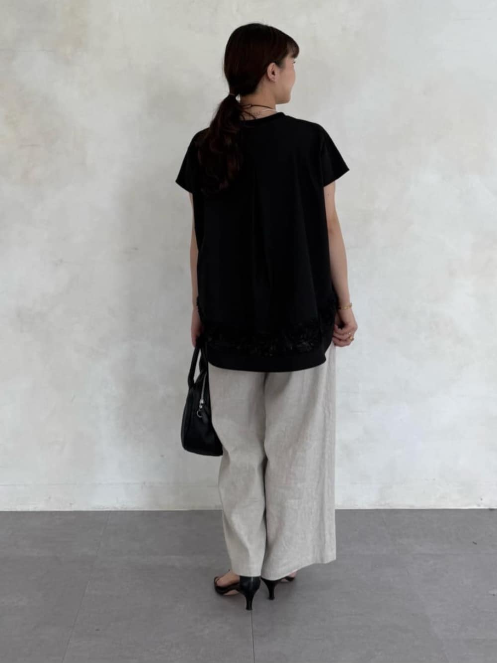 ブラック系のTシャツ/カットソーを着用したレディースの春コーディネートの3枚目の写真