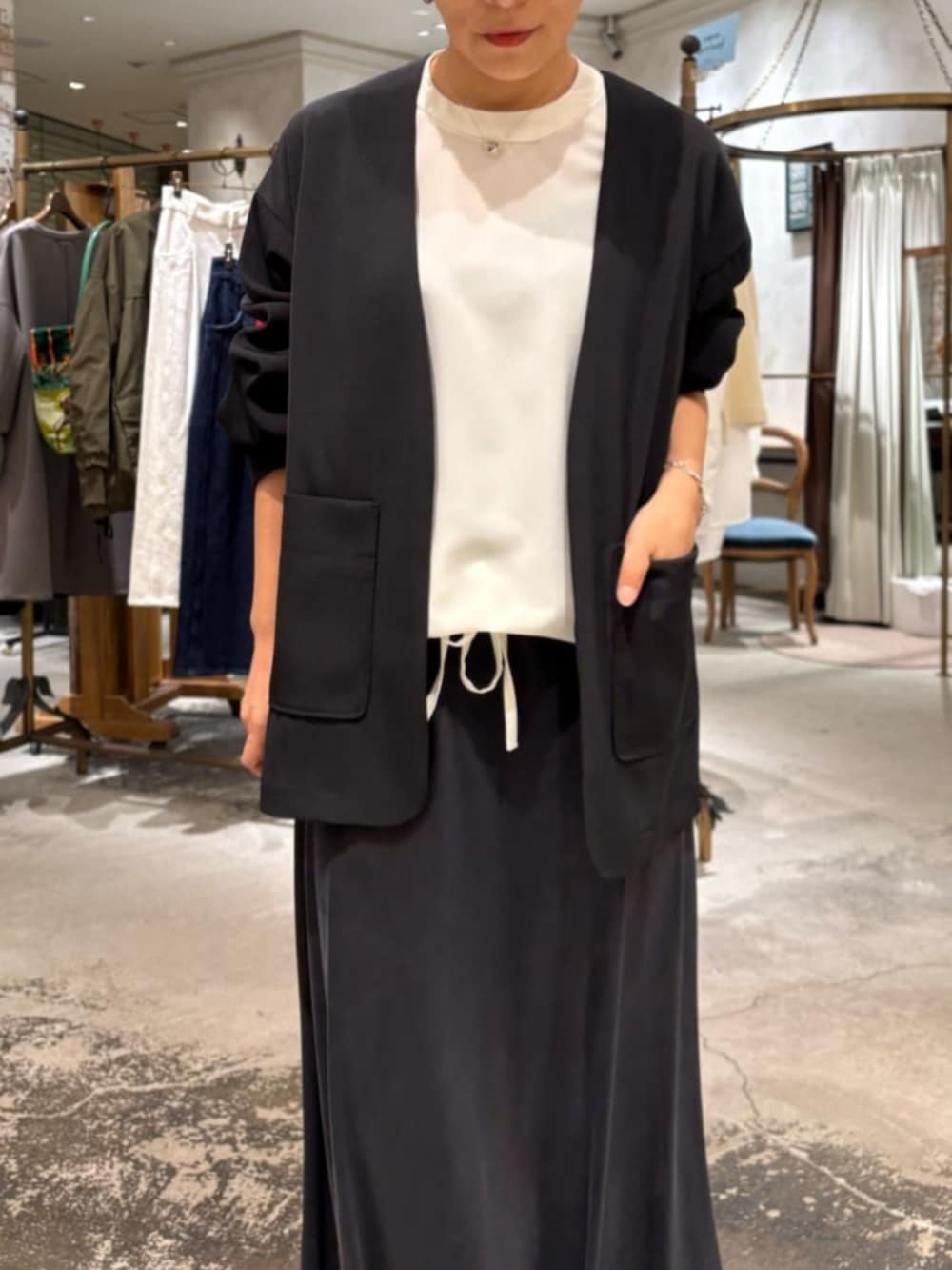 ブラック系のスカート、ベージュ系のトートバッグ、ホワイト系のシャツ/ブラウスを着用したレディースの冬コーディネートの4枚目の写真