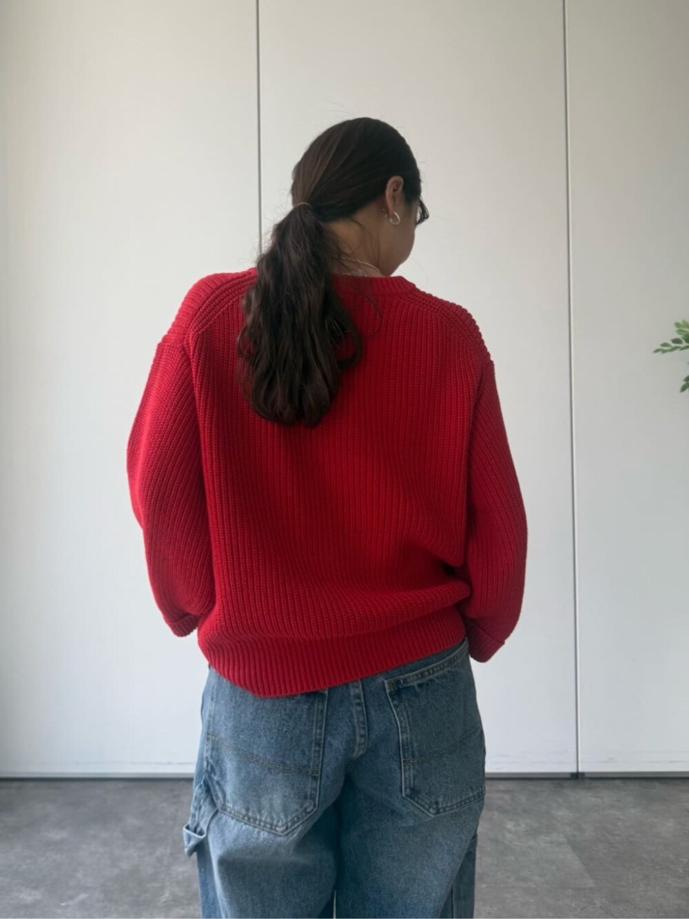 レッド系のニット/セーター、グレー系のトートバッグを着用したレディースの冬コーディネートの7枚目の写真