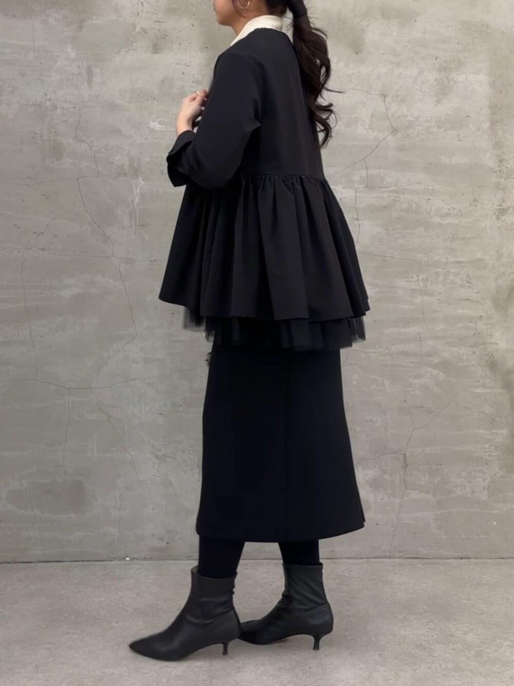 ブラック系のスカート、ブラック系のブルゾンを着用したレディースの冬コーディネートの3枚目の写真