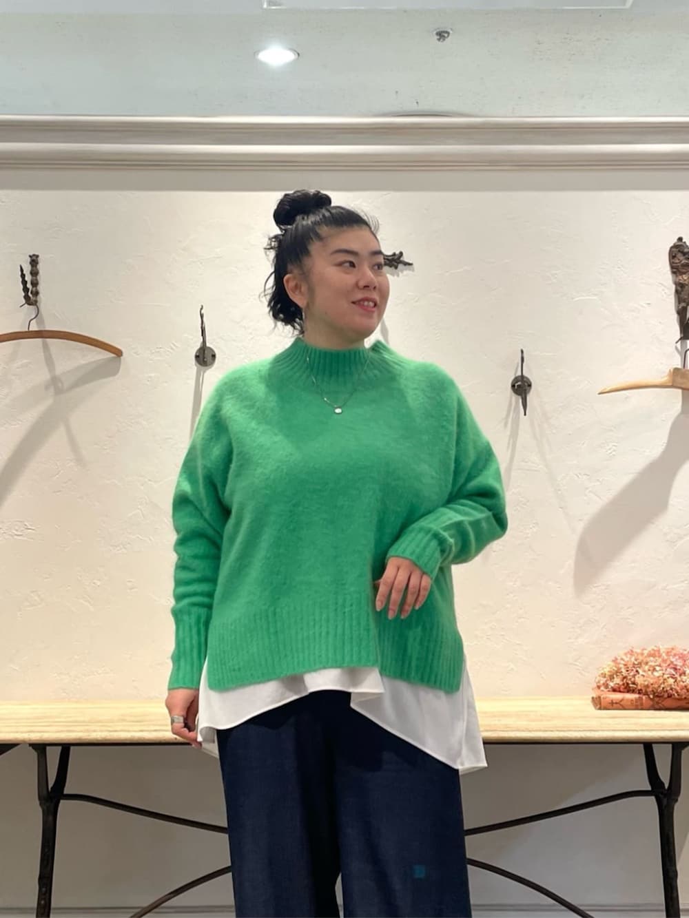 ホワイト系のTシャツ/カットソー、グリーン系のニット/セーター、ブルー系のその他パンツを着用したレディースの冬コーディネートの4枚目の写真