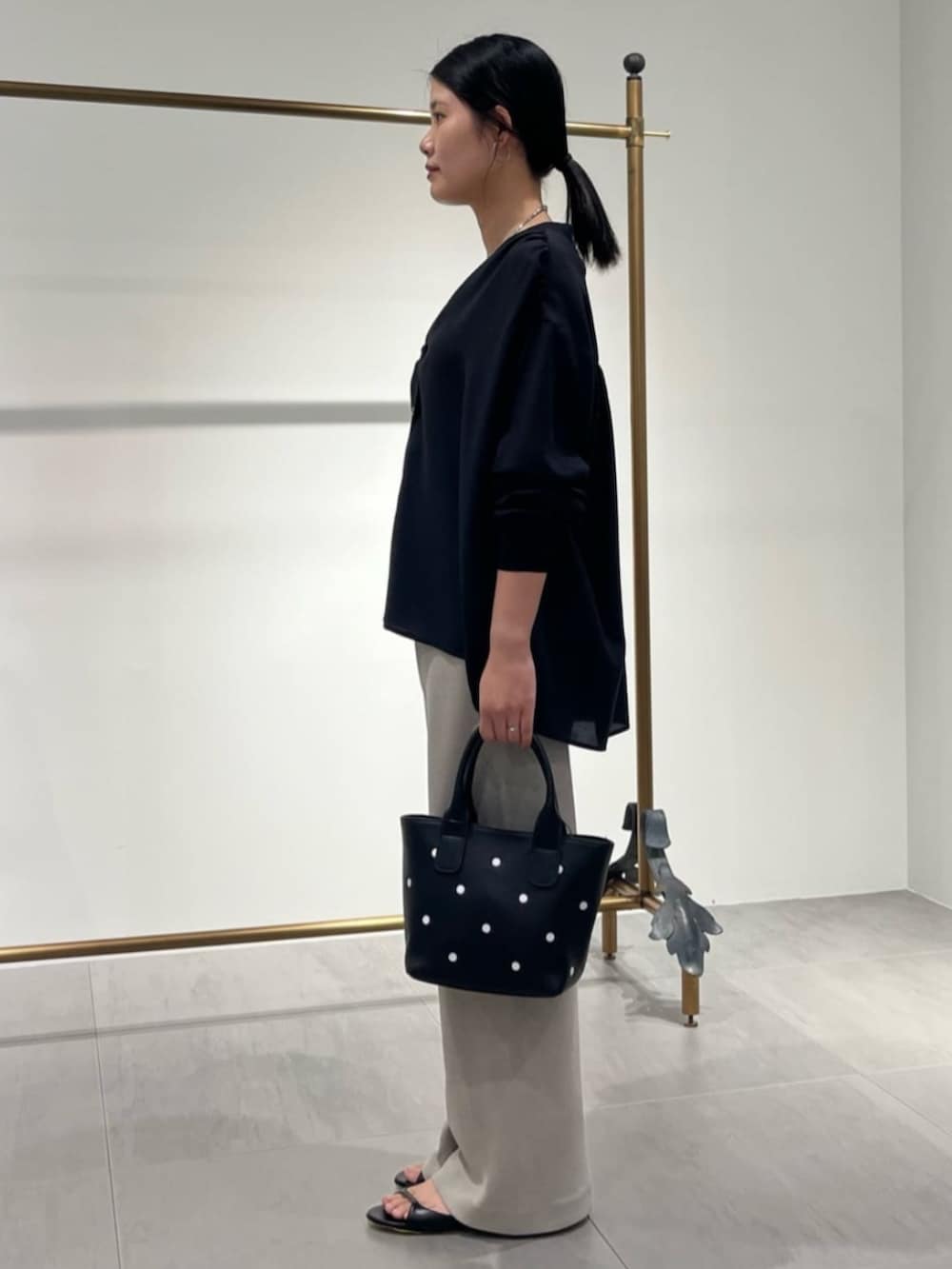 ブラック系のトートバッグ、ブラック系のシャツ/ブラウス、ベージュ系のその他パンツを着用したレディースの夏コーディネートの2枚目の写真