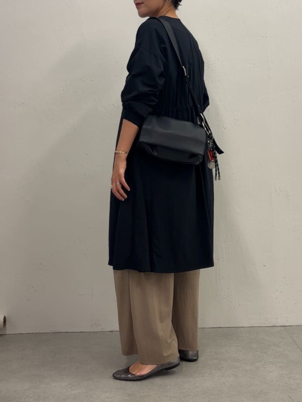ブルー系のその他アウター、ベージュ系のその他パンツ、ブラック系のTシャツ/カットソーを着用したレディースの冬コーディネートの3枚目の写真