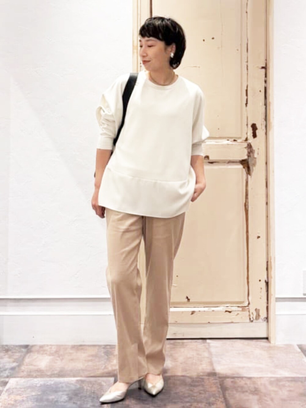 ブラック系のショルダーバッグ、ホワイト系のTシャツ/カットソー、ベージュ系のその他パンツを着用したレディースの夏コーディネートの2枚目の写真