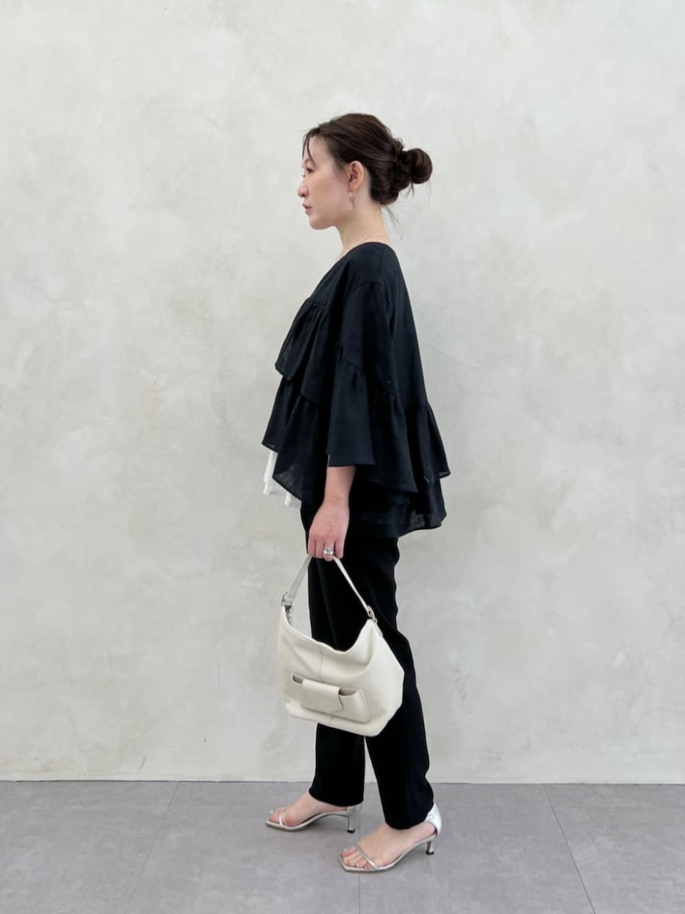 ホワイト系のトートバッグ、ブラック系のその他パンツ、ホワイト系のシャツ/ブラウスを着用したレディースの春コーディネートの4枚目の写真