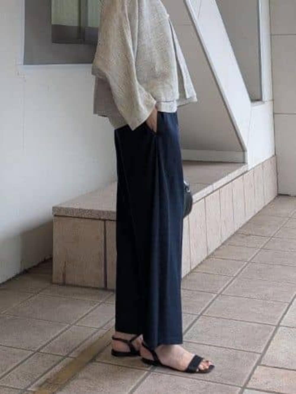 ブルー系のその他パンツ、ブラック系のボストンバッグ、グレー系のニット/セーターを着用したレディースの冬コーディネートの6枚目の写真