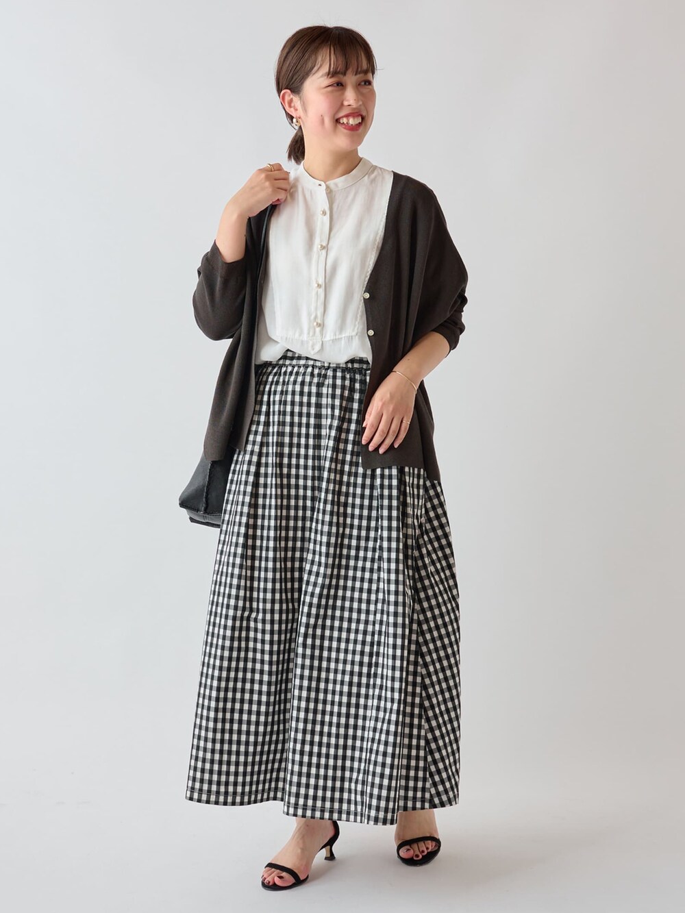 グレー系のカーディガン/ボレロ、ホワイト系のシャツ/ブラウス、ホワイト系のショルダーバッグを着用したレディースの夏コーディネートの2枚目の写真