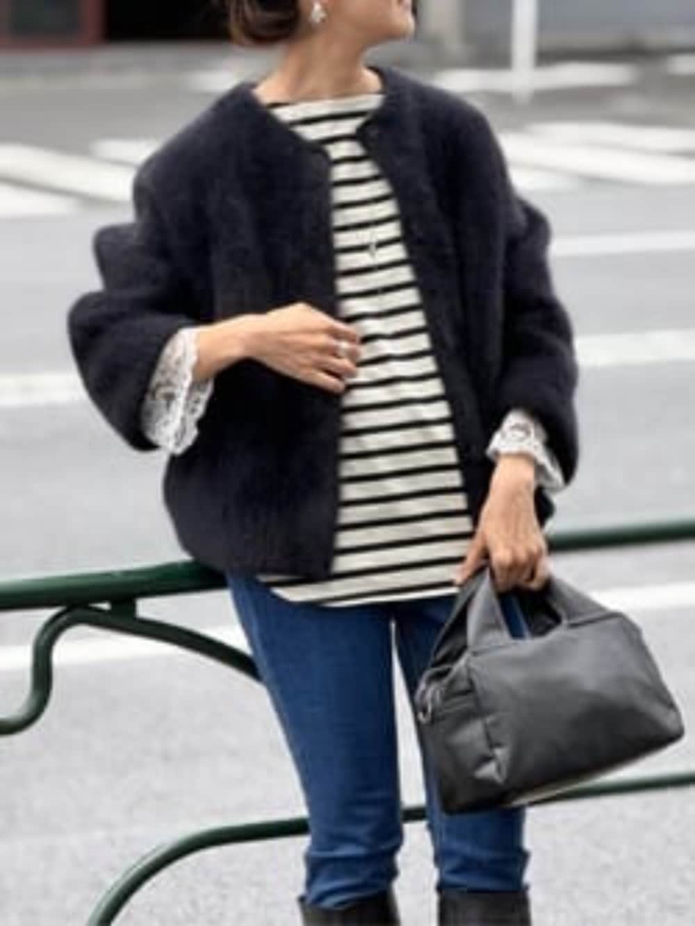 ブルー系のデニムパンツ、ブラック系のその他アウター、ブラック系のボストンバッグを着用したレディースの夏コーディネートの6枚目の写真