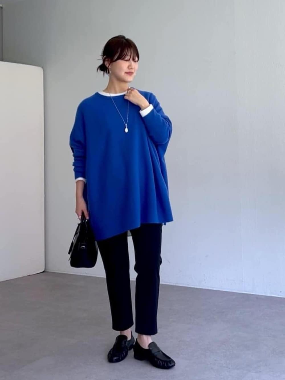 ブラック系のローファー、ブラック系のその他パンツ、ブルー系のニット/セーターを着用したレディースの秋コーディネートの10枚目の写真