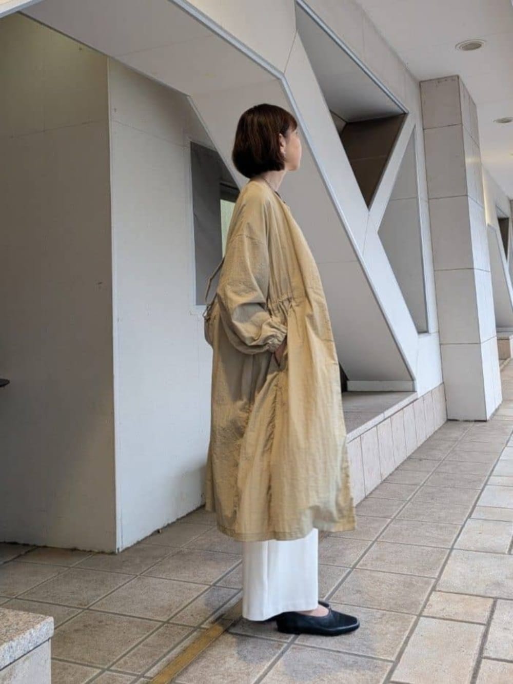 ベージュ系のその他アウター、ホワイト系のその他パンツ、ブラック系のTシャツ/カットソーを着用したレディースの冬コーディネートの2枚目の写真