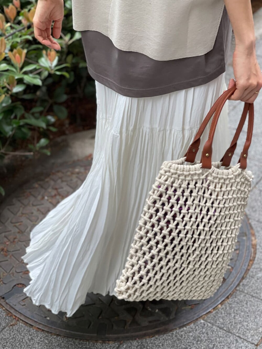 ベージュ系のカーディガン/ボレロ、ブラウン系のTシャツ/カットソー、ホワイト系のスカートを着用したレディースの春コーディネートの5枚目の写真