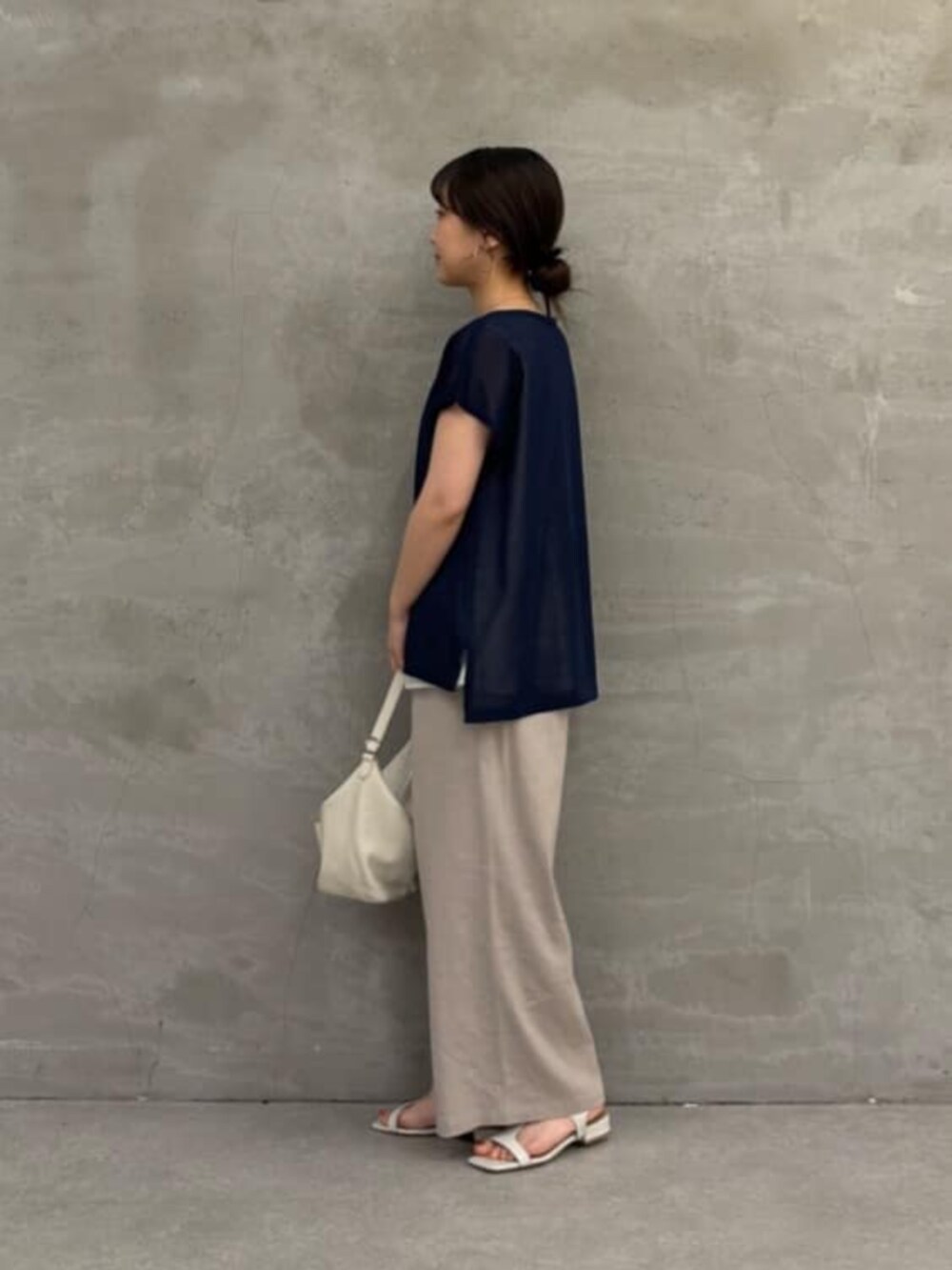 ホワイト系のトートバッグ、グレー系のその他パンツ、ブルー系のニット/セーターを着用したレディースの春コーディネートの5枚目の写真