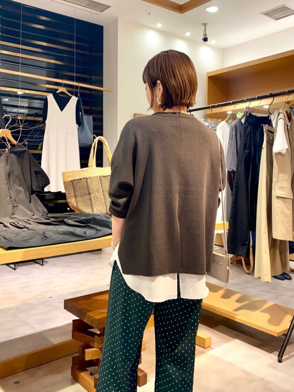 グレー系のカーディガン/ボレロ、ホワイト系のシャツ/ブラウス、グレー系のショルダーバッグを着用したレディースの夏コーディネートの3枚目の写真