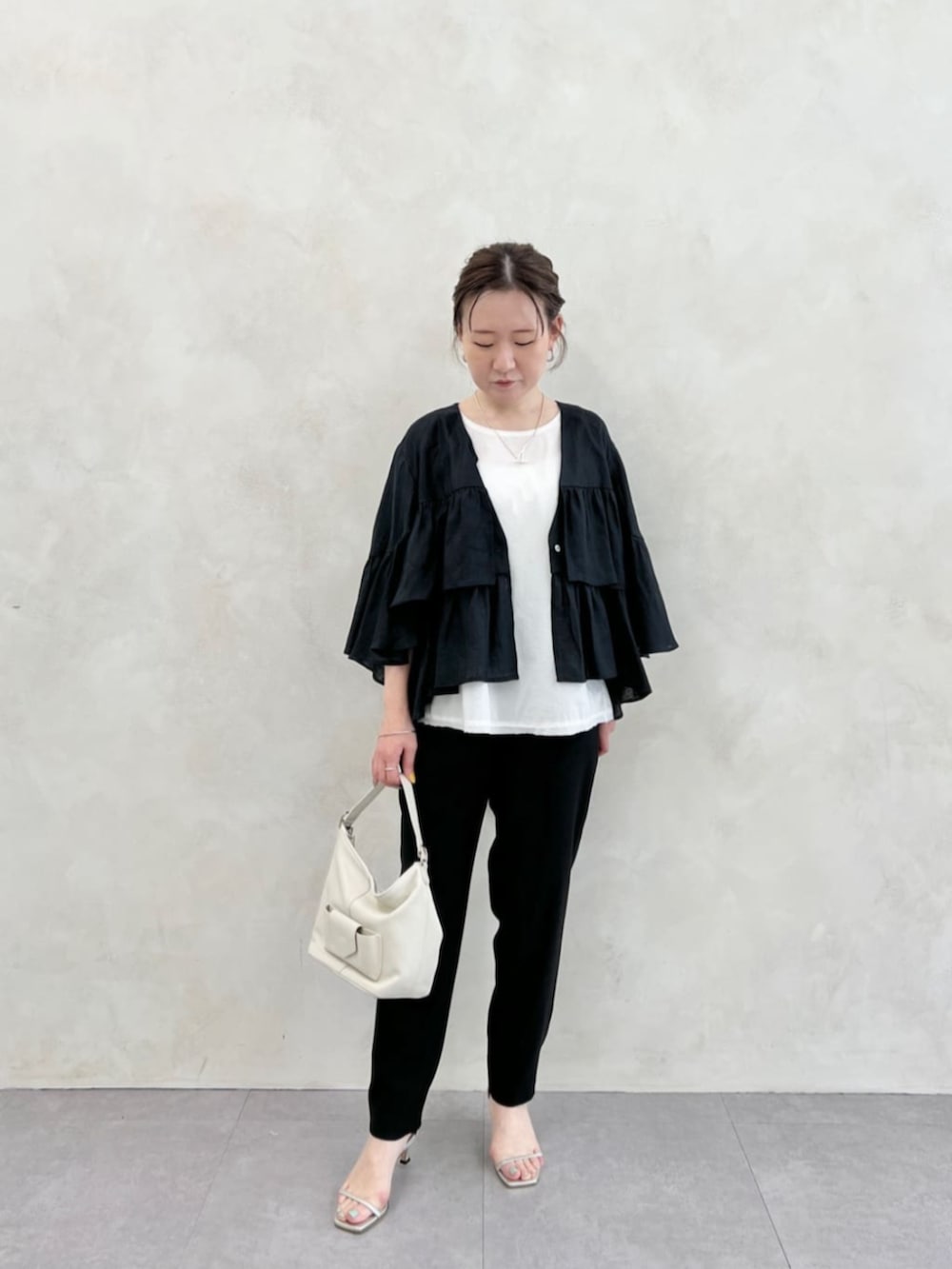 ホワイト系のトートバッグ、ブラック系のその他パンツ、ホワイト系のシャツ/ブラウスを着用したレディースの春コーディネートの3枚目の写真