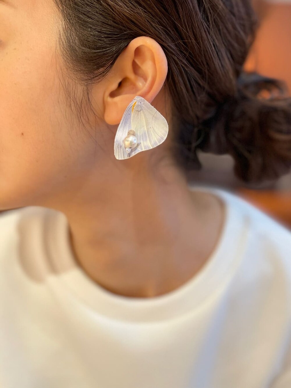 ホワイト系のTシャツ/カットソー、ベージュ系のスカート、ホワイト系のスニーカーを着用したレディースの冬コーディネートの5枚目の写真