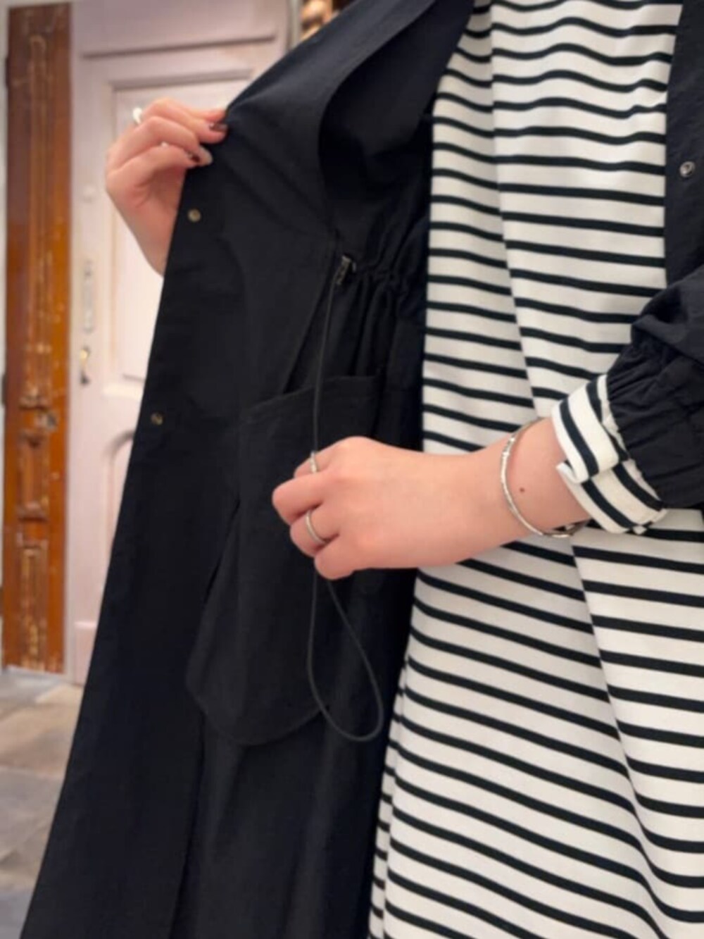 ブラック系のその他アウター、ブルー系のデニムパンツ、ブルー系のTシャツ/カットソーを着用したレディースの冬コーディネートの6枚目の写真