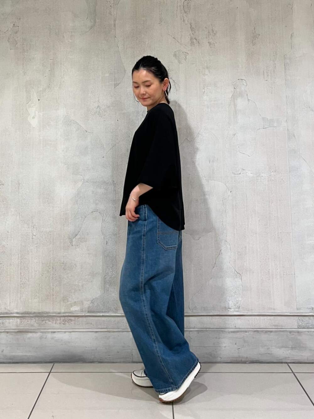 ブルー系のその他パンツ、ブラック系のTシャツ/カットソー、ホワイト系のスニーカーを着用したレディースの春コーディネートの3枚目の写真