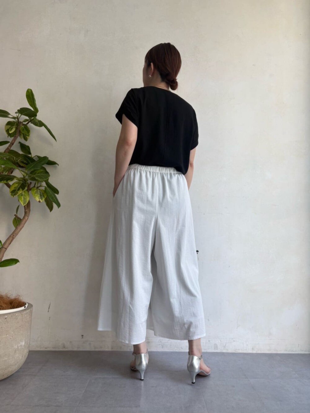 ブラック系のボストンバッグ、ホワイト系のその他パンツ、ブラック系のベストを着用したレディースの春コーディネートの5枚目の写真