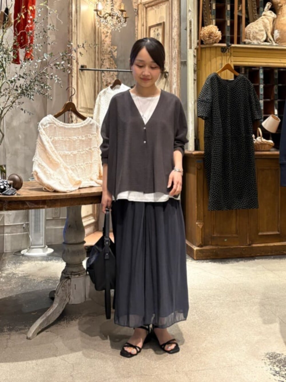 ブラック系のその他パンツ、ホワイト系のシャツ/ブラウス、グレー系のカーディガン/ボレロを着用したレディースの春コーディネートの4枚目の写真