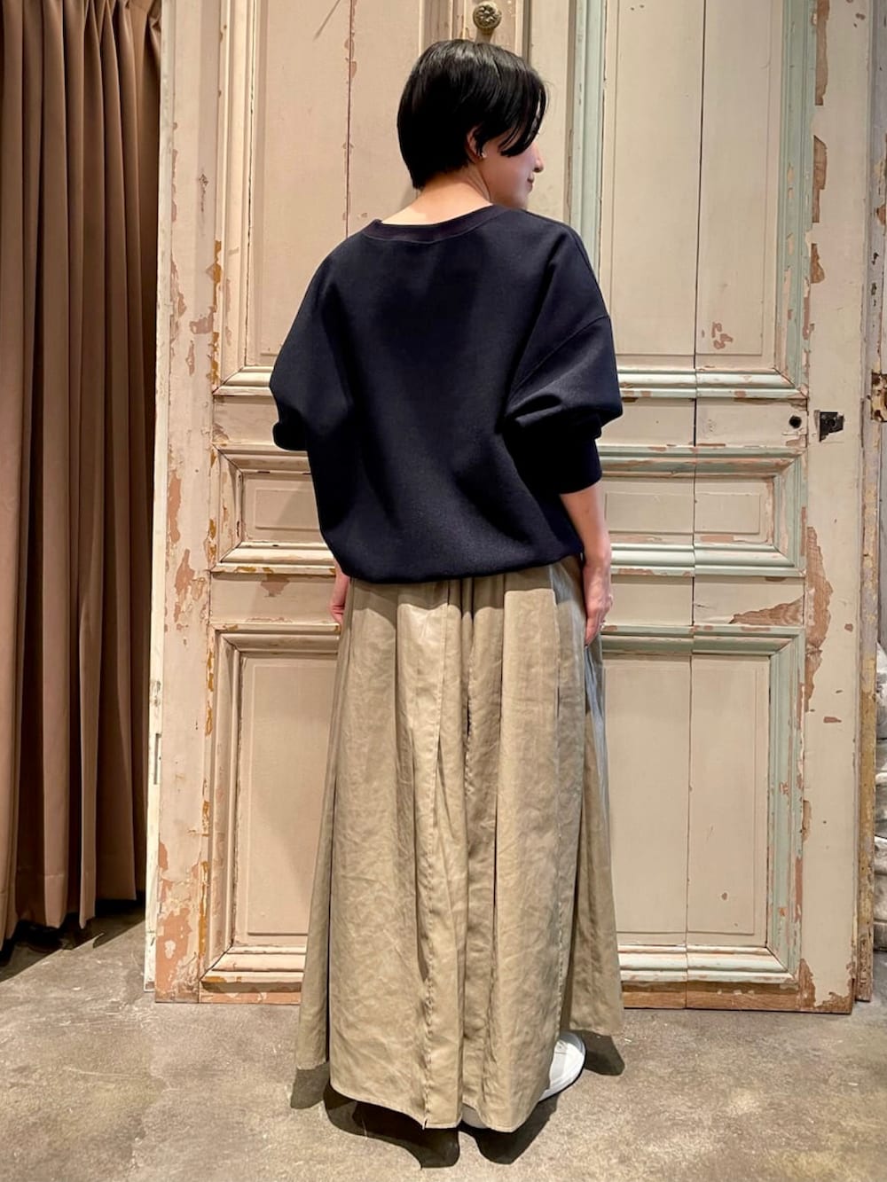 ブルー系のTシャツ/カットソー、グリーン系のスカート、ホワイト系のスニーカーを着用したレディースの秋コーディネートの3枚目の写真