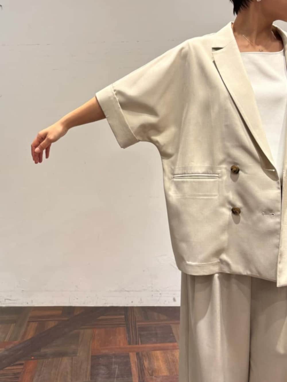 ブラック系のハンドバッグ、ベージュ系のテーラードジャケット、ベージュ系のその他パンツを着用したレディースの春コーディネートの6枚目の写真