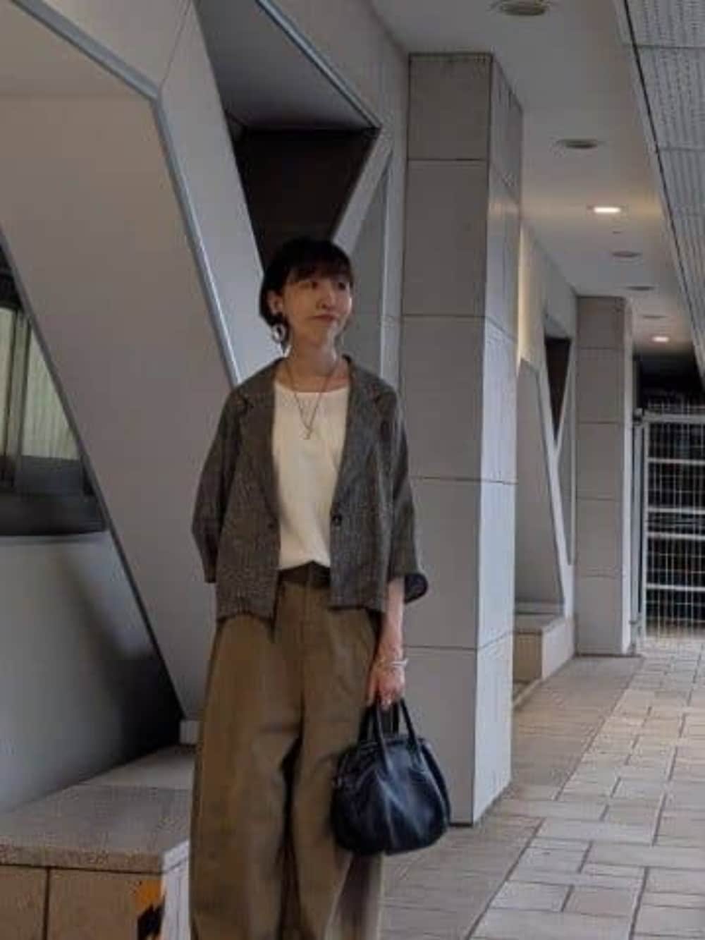 ブラック系のボストンバッグ、イエロー系のその他パンツ、ベージュ系のテーラードジャケットを着用したレディースの夏コーディネートの4枚目の写真