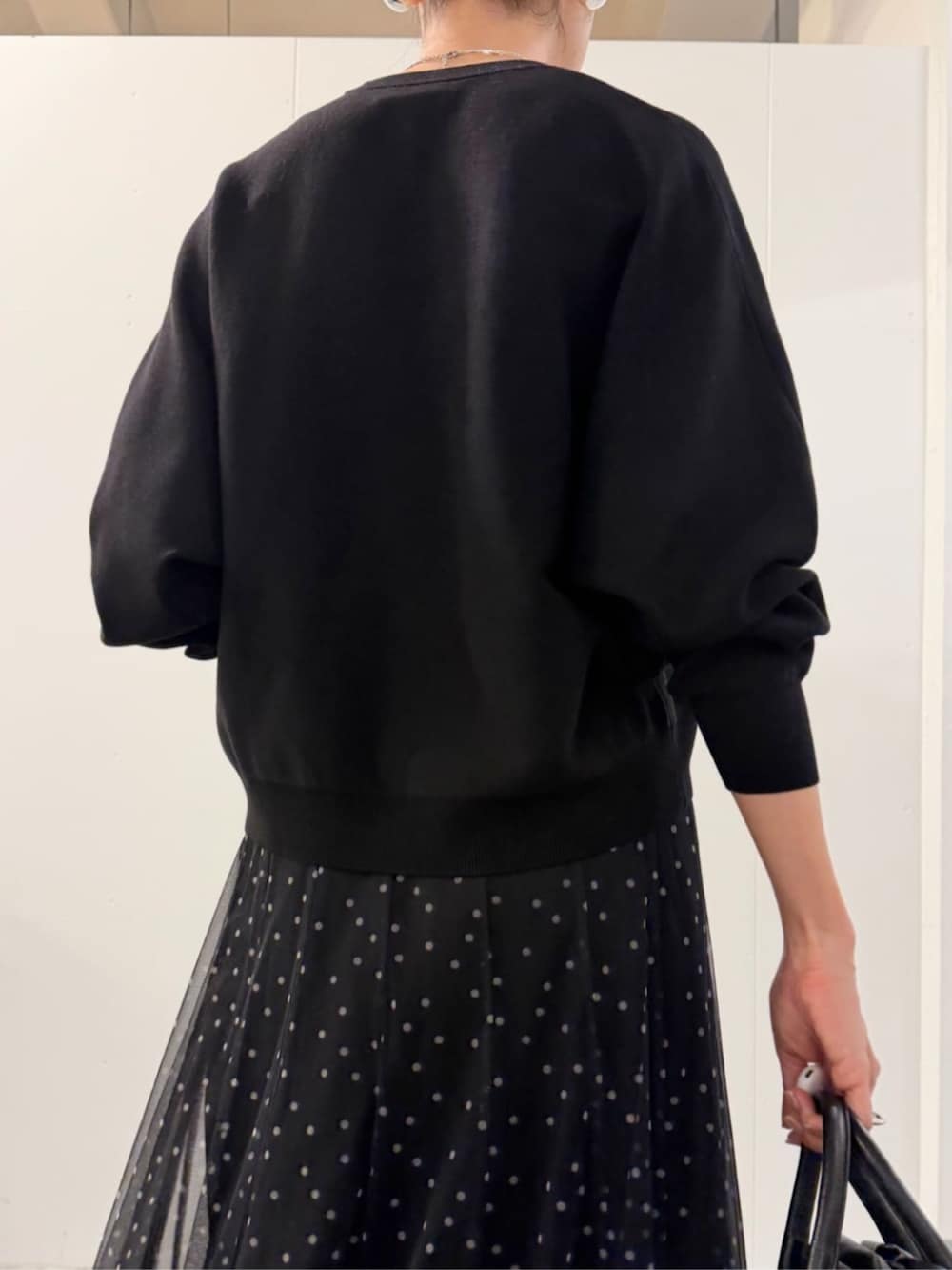 ブラック系のスカート、ブラック系のブーツ、ブラック系のニット/セーターを着用したレディースの夏コーディネートの8枚目の写真